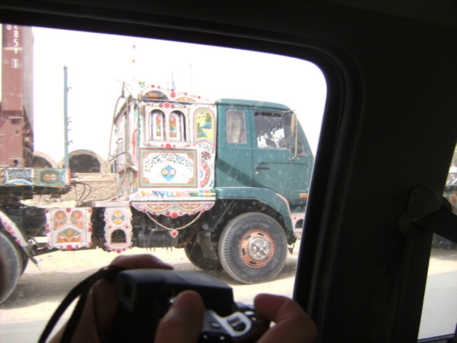 A painted truck outside the wire, from the convoy window